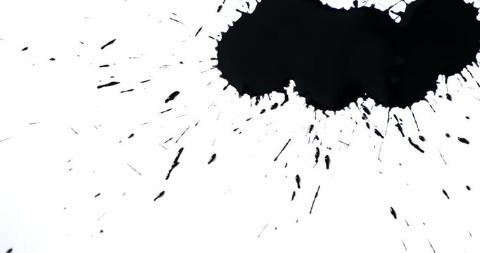 Black spots on a white background. Ink spills onto white paper. Black drops and white surface.