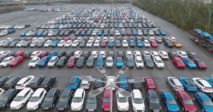 High angle view of numerous new cars parked in rows at a large automotive factory distribution lot