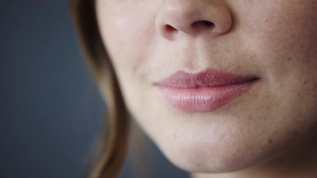 Cosmetics, lips and woman with smile in studio for dermal filler, synthetic hyaluronic acid and results. Dermatology, person or mouth closeup on gray background with HA treatment, volume or aesthetic