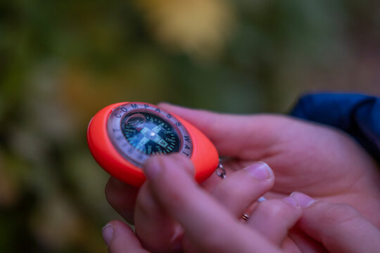 Teenager holding compass in forest, orientation, survival skills, getting lost in woods, searching for way, Young explorer adventure, outdoor challenge, nature exploration, hope and outdoor survival