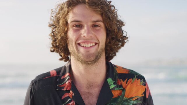 Fashion, happy and face of man on beach for vacation, holiday and travel for adventure outdoor. Style, nature and portrait of person by ocean for spring break, trip and relax on weekend for tourism