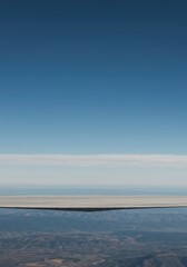 Fototapeta premium A wide, expansive view of the clear atmosphere meeting the distant flat surface, creating a peaceful and open background, panorama, line, space