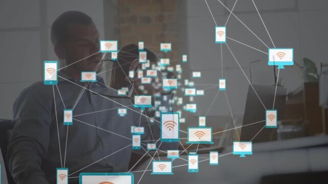 Office colleagues mapping network with device icons forming around laptop while man placing call