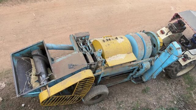 Multi-crop agricultural thresher machine parked in a rural field