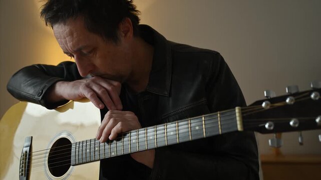 Uninspired guitarist holding an acoustic guitar and thinking, showing creative block, 4K