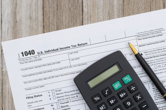 US 1040 tax form with calculator and pen