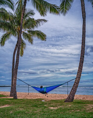 Fototapeta premium Beachcomber living in a Hammock with an Ocean Background.
