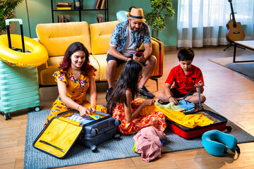 Young Indian parents and children packing bags for a happy family vacation