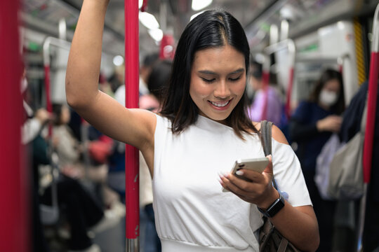 Young Thai Woman Using Smartphone on Hong Kong Subway MTR