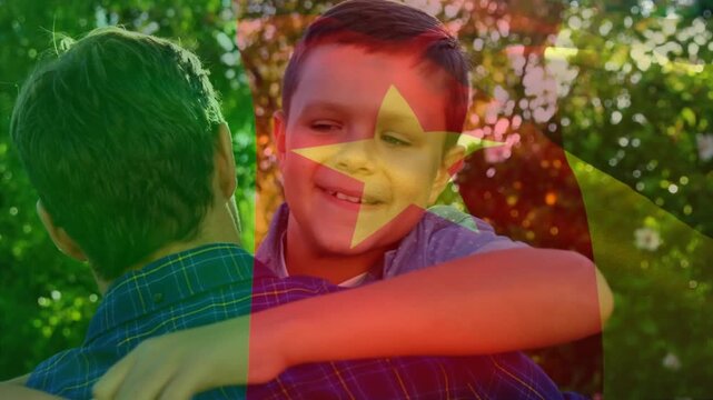 Animation of flag of cameroon over happy caucasian father and son embracing outdoors