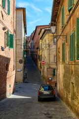 Fototapeta premium Medieval narrow street in Siena, Tuscany, Italy. Architecture and landmark of Siena. Cozy cityscape of Siena