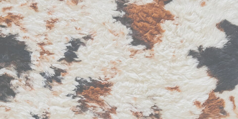 Soft faux fur fabric with a brown black and white cow print pattern © ZenVectors