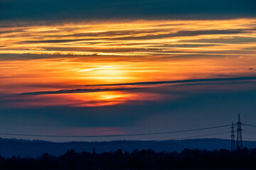 Fototapeta premium Sonnenuntergang und Hochspannungsmasten