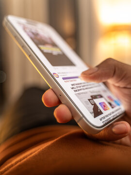 Scrolling social media feed mindlessly, indoor room illuminated by warm tone light. Digital addiction and mindless content consuming in Bangalore, India, on February 28, 2026