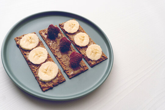 Peanut butter toast with banana and raspberry