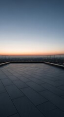 Obraz premium Modern rooftop terrace at sunset with city lights and clear sky, offering a serene urban vista and a sense of elevated tranquility.