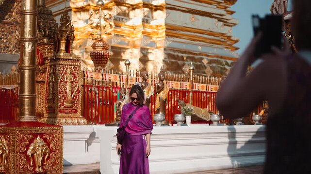 Elegant tourist posing for a photo at a beautiful golden buddhist temple