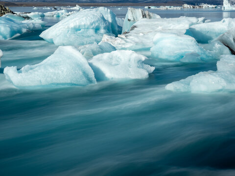 Icebergs floating in bright blue water of Iceland's Glacier Lagoon, long exposure