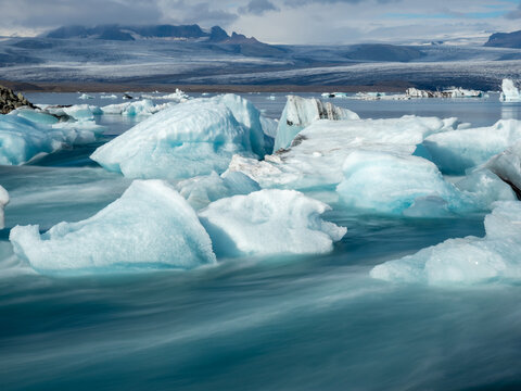 Icebergs flowing into the ocean along the narrow strait from Iceland's Jokulsarlon Glacier Lagoon, long exposure