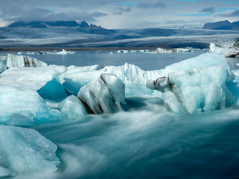Icebergs flowing into the ocean along the narrow strait from Iceland's Jokulsarlon Glacier Lagoon, long exposure