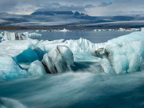 Icebergs flowing into the ocean along the narrow strait from Iceland's Jokulsarlon Glacier Lagoon, long exposure