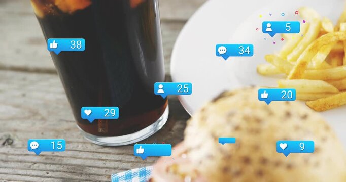 Vertical video: Likes popping as blue bubbles growing around cola, fries, burger on rustic table