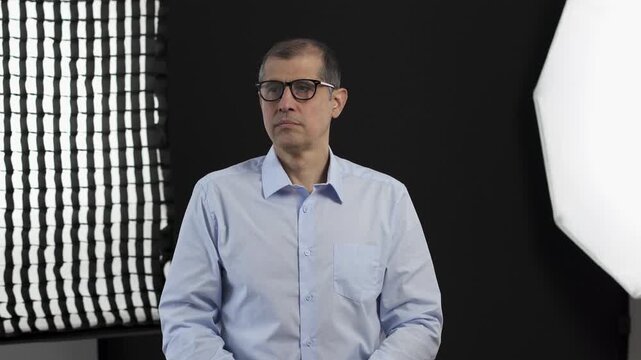 Set, man and preparation for film, production or interview with mature celebrity. Creative, fashion and art director in studio getting ready with glasses for tv show, media and live stream broadcast