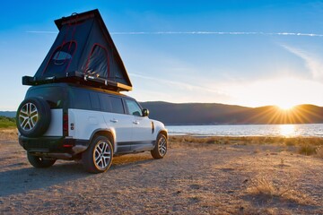 Off road car with roof tent in the wild campground.  Great Prespansko Lake on the border North Macedonia, Greece and Albania. © Tunatura