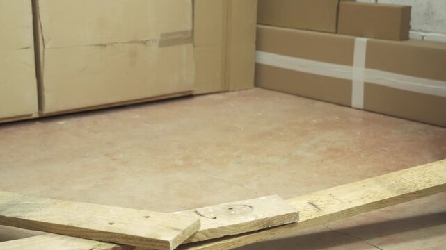Close up of a construction worker stumbling with a cord in a warehouse