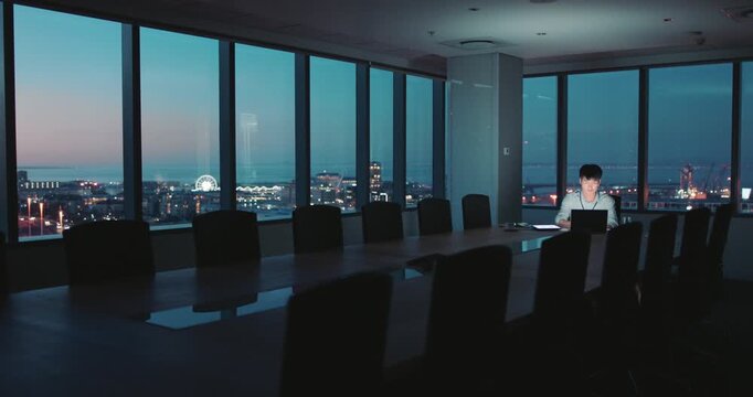 Man, laptop and night at office for proposal with project management, deadline or late at insurance company. Person, broker or advisor with tech, review report and computer at risk assessment agency