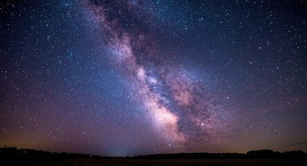 Fototapeta premium Purple and blue Milky Way galaxy spanning across a clear starry night sky landscape