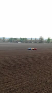 CHERKASY, UKRAINE, APRIL 28, 2020: Tractors planting potatoes on sunny field