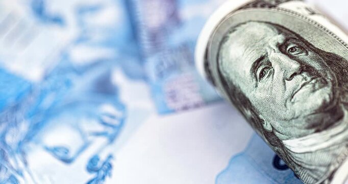 Detail video of a Brazilian one-hundred-real note, next to one-hundred American dollar notes. Economic crisis and rise in the American currency, rise or fall of the dollar in reference to the Brazilia