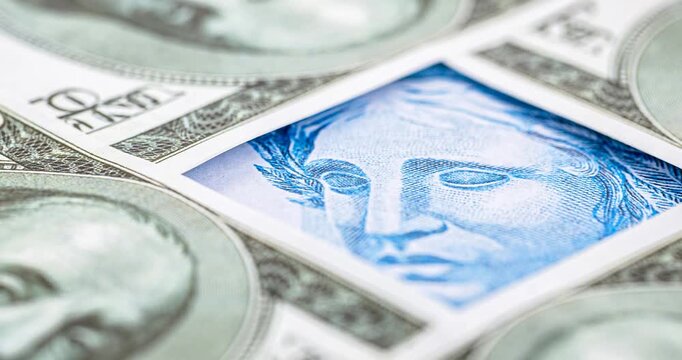 Detail video of a Brazilian one-hundred-real note, next to one-hundred American dollar notes. Economic crisis and rise in the American currency, rise or fall of the dollar in reference to the Brazilia