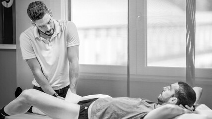 Osteopath practising physiotherapy on a couch on a man's leg