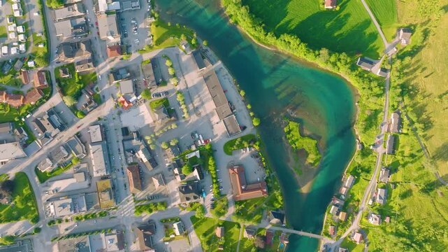 Aerial drone view of a river valley in Stryn, Norway. Scenic road through mountain fjords and green meadows under summer sunlight. Professional horizontal footage of Scandinavian travel destination.