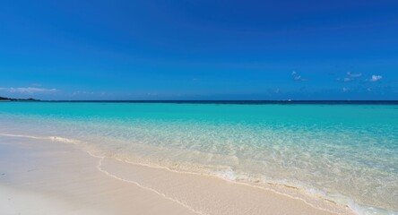 Obraz premium Relaxed coastal scene highlighting fine white sand and clear turquoise ocean under vivid blue sky