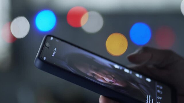 Finger scrolling through social media feed on smartphone at night