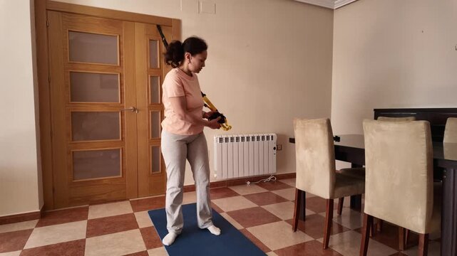 Woman Engages In Suspension Training For Home Fitness