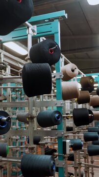 Thread spools in textile industry: weaving racks, dyeing and drying for fabric production.