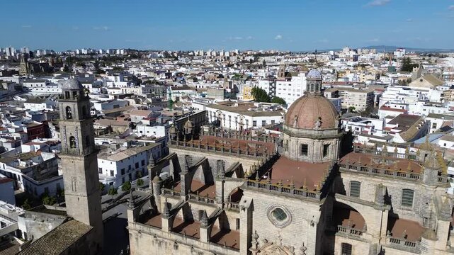 Aerial drone shot in 4K resolution starting with a close up of the Jerez Cathedral dome and moving backwards to reveal a wide panoramic view of the historic city center and skyline
