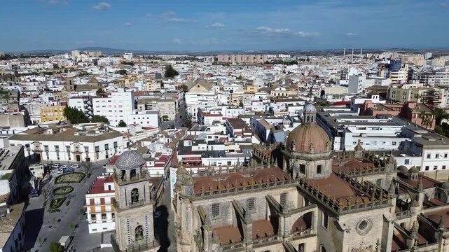 Aerial drone shot moving backwards in 4K resolution revealing a spectacular and wide panoramic view of the Jerez Cathedral and the entire historic city center under a clear sunny sky
