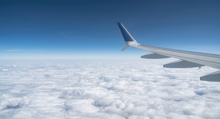 Obraz premium High altitude airplane wing flight amid a peaceful white cloudscape