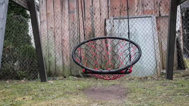 Garden Swing Moving in Strong Wind With Empty Hanging Seat Outdoors