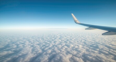 Obraz premium Peaceful airplane wing view flying high over soft white clouds