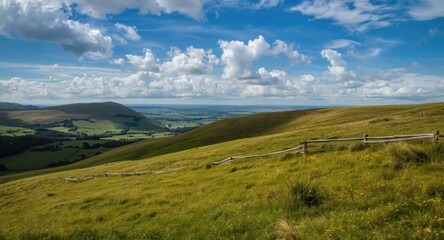 Fototapeta premium Scenic hillside panorama with vibrant grass and rolling hills under a bright sky with scattered clouds