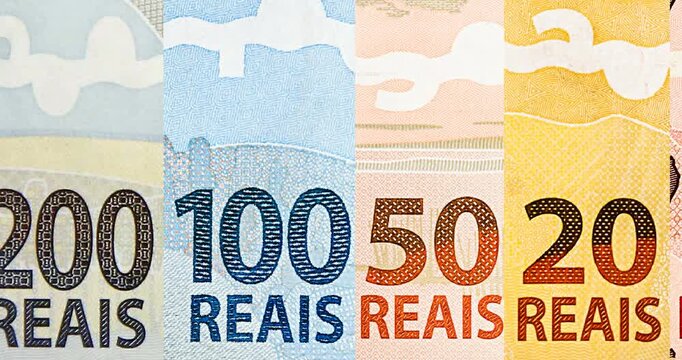details of banknotes of 100 reais from brazil, and brazilian coins, with selective focus, background image. Promotion concept or grand prize money.