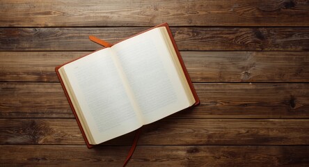 Fototapeta premium Birds eye perspective of open blank book on aged wooden tabletop