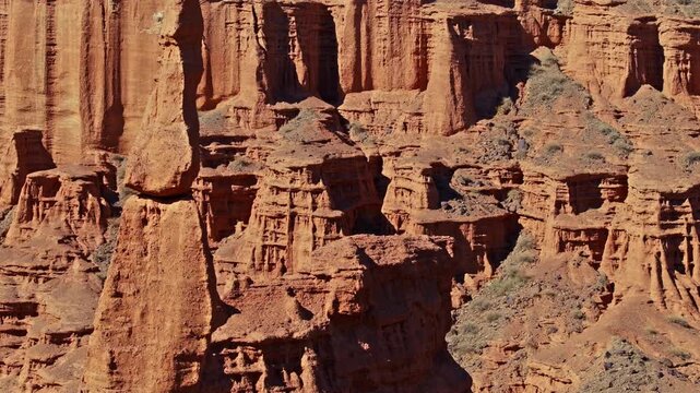 Aerial view captures stunning rock formations and eroded cliffs in Kyrgyzstan's desert canyon. Rugged landscape showcases natural beauty during daytime.