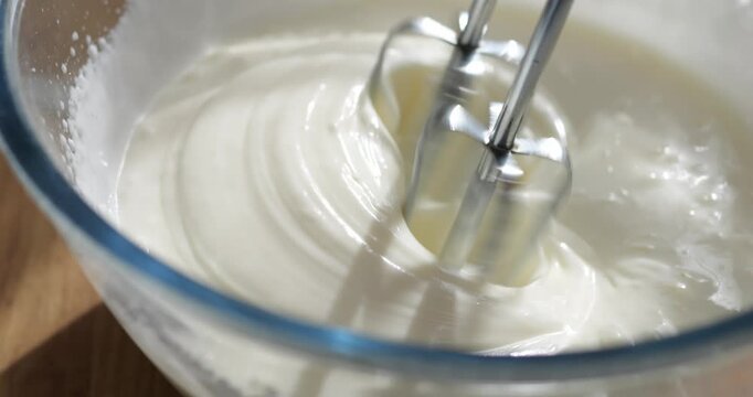 Beat the cream for the cake with a mixer. Confectionery mixture for greasing the cakes.